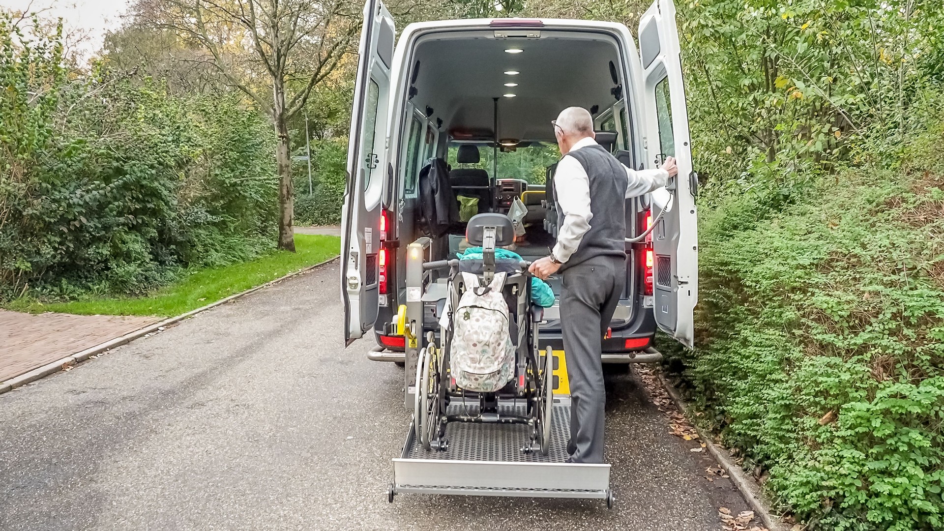 A senior retired man helping to transport disabled people