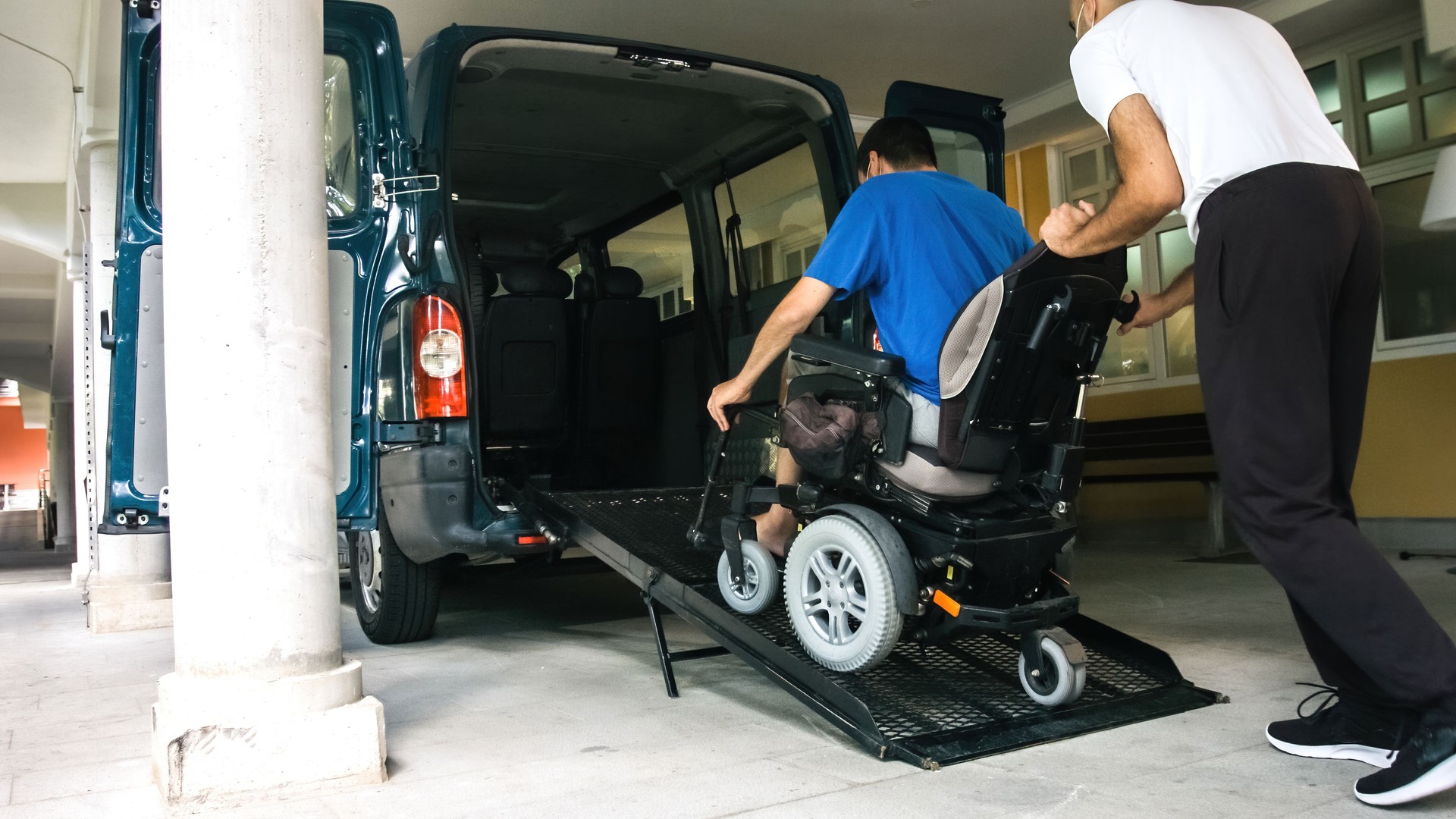 Man on wheelchair using vehicle ramp
